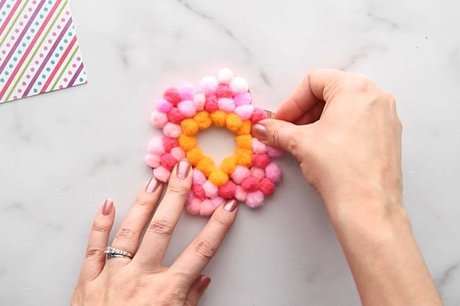 Finish gluing pom poms to flower