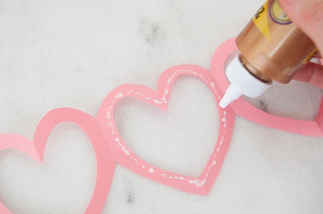 Applying glue to pink garland