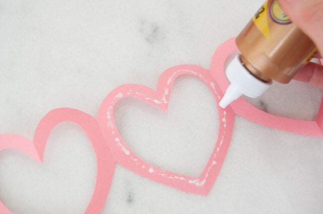 Applying glue to pink garland