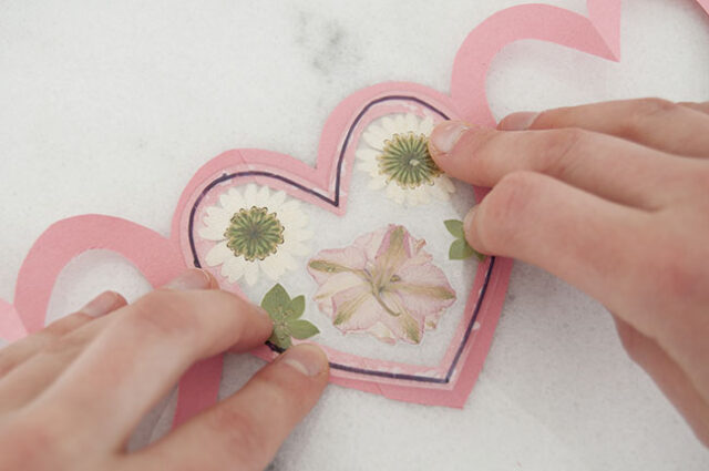Attaching laminated heart to pink garland