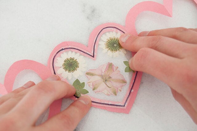 Attaching laminated heart to pink garland