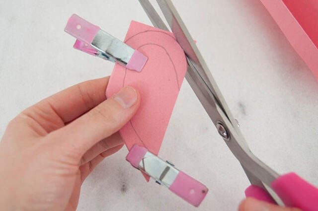 Cutting out pink paper heart