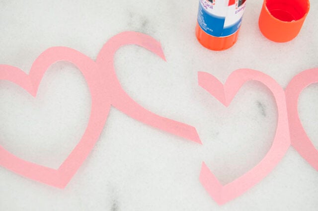 Gluing pink paper garland together