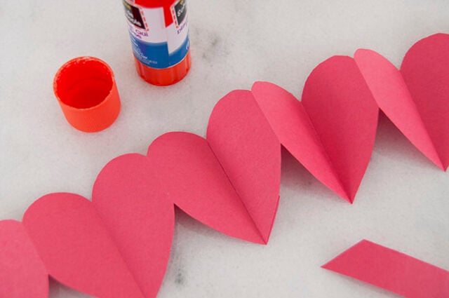 Gluing red paper garland together