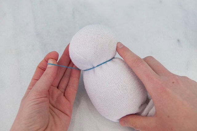 Wrapping elastic band onto snowman