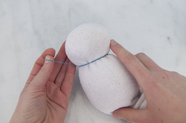 Wrapping elastic band onto snowman