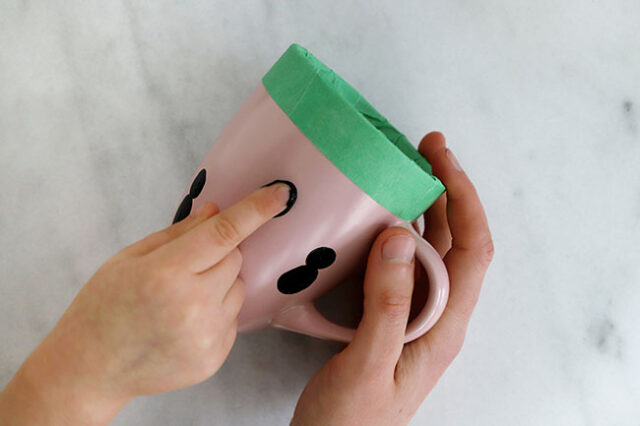 Stamping finger onto mug for penguin