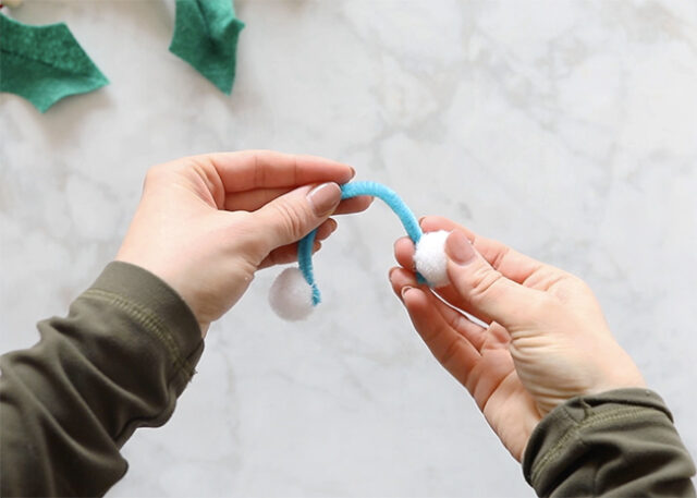 Gluing pom poms onto pipe cleaner