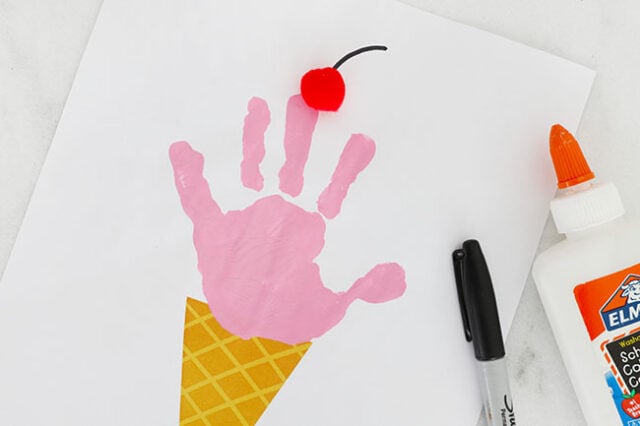 Gluing pom pom onto ice cream handprint