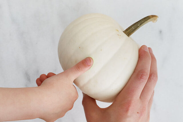 Stamping green Frankenstein dots onto pumpkin